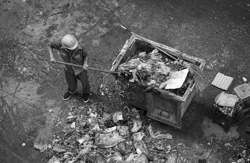 Man and van loading treated wood in a busy urban location